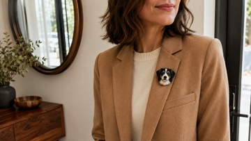 Woman wearing a dimensional wool pet portrait brooch securely on a camel blazer lapel