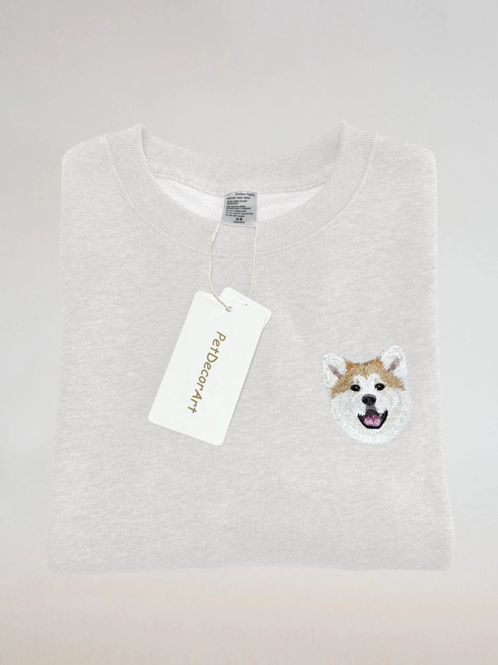 Custom hand embroidered pet portrait T-shirt featuring a small dog portrait on a white shirt